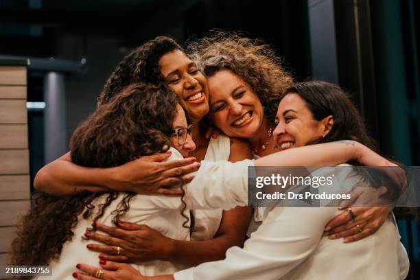female friends hugging each other on new year's eve - abraço imagens e fotografias de stock