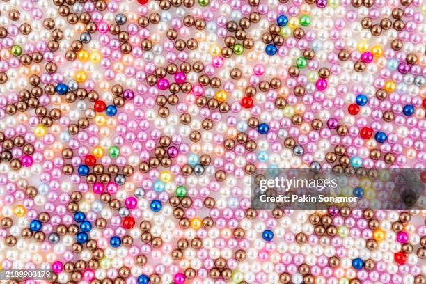 multicolored beads background. mix of shiny different color plastic bead, top view. - bead stock pictures, royalty-free photos & images