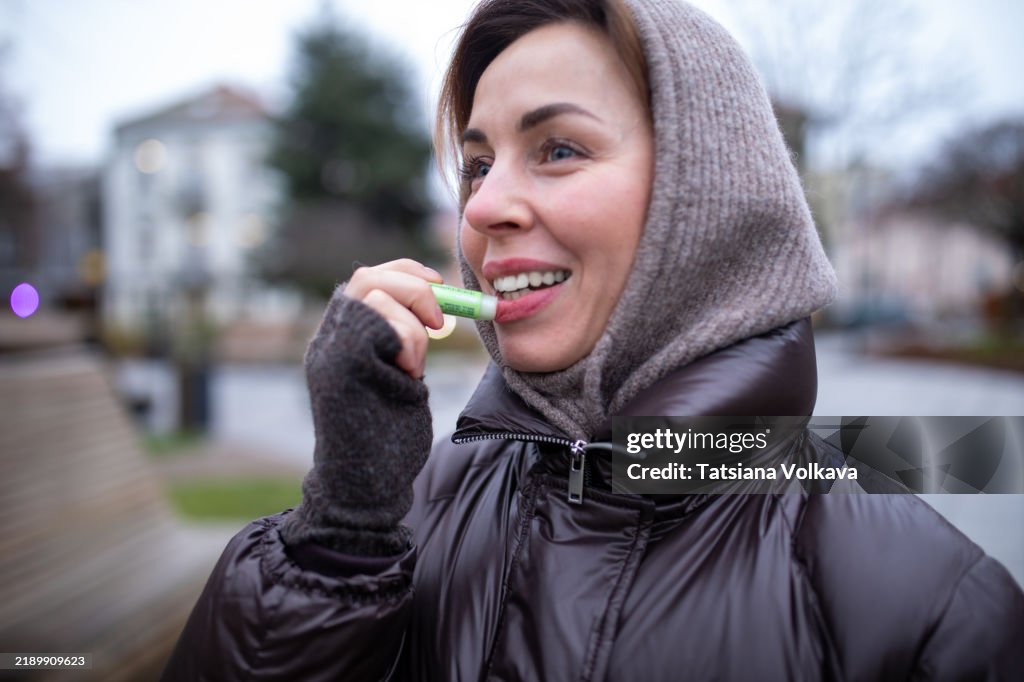 Woman Applying Lip Balm Outdoors