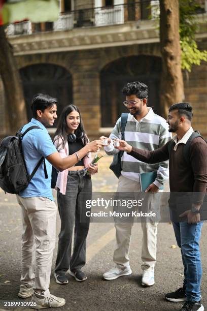 university students spending time at a roadside tea stall - tea stall stock pictures, royalty-free photos & images