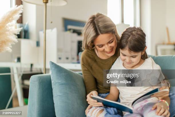 auntie and niece reading a book - tia imagens e fotografias de stock