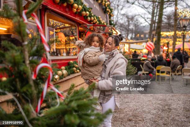 lifestyle shoot of a beautiful mixed race mother and son at a christmas market - julmarknad bildbanksfoton och bilder
