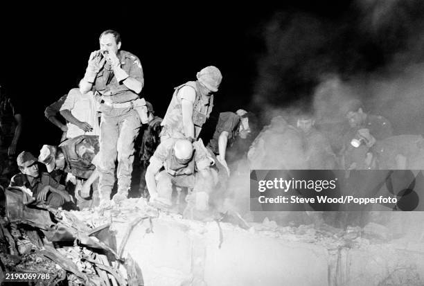 Rescuers comb the wreckage of the four-storey barracks of the US Marines which was destroyed the previous day by suicide bombers, killing 241...