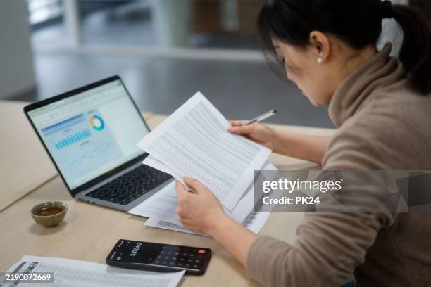 asian businesswoman use the calculator in the mobile phone to calculate. - accountancy stock pictures, royalty-free photos & images