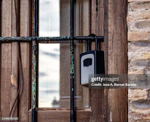 code-locked key box on an apartment window in a vacation rental. - candado fotografías e imágenes de stock