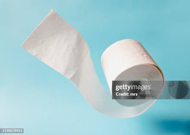 toilet paper on blue background - carta igienica foto e immagini stock