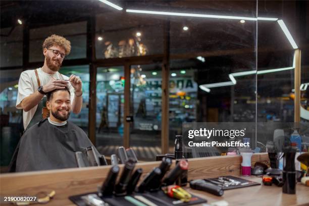 taglio dei capelli in un barbiere alla moda - negozio del barbiere foto e immagini stock