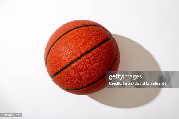 overhead view of basketball on white background - basketball stock-fotos und bilder