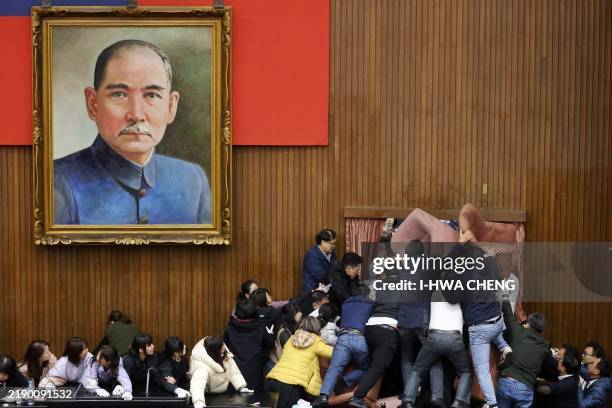 Lawmakers from the main opposition Kuomintang try to break into Parliament where Democratic Progressive Party occupied the night to avoid the passing...