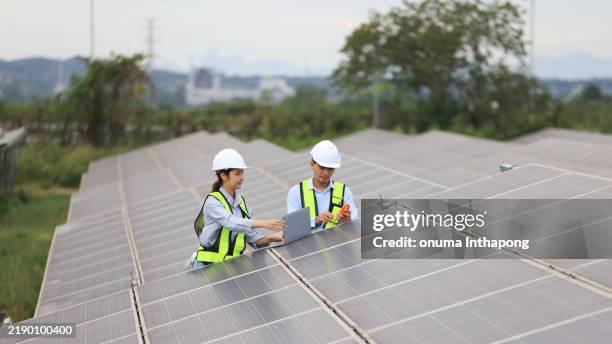 two solar engineers are inspecting the solar farm site thoroughly. they focus on implementing zero-carbon credit strategies and promoting green energy initiatives. their expertise and dedication are crucial in advancing sustainable energy solutions. - green technology stock pictures, royalty-free photos & images