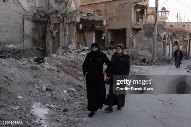 Women walk past the ruined buildings on December 15, 2024 in Aleppo, Syria. Aleppo was the first major city to fall in last week's lightning...