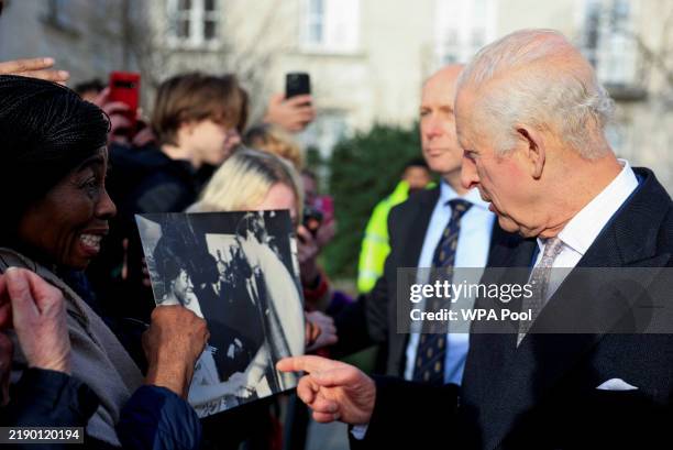 Caroline Akuffo shows King Charles III an old photograph of them meeting in Japan in 1970, during a reception at Waltham Forest Town Hall on December...
