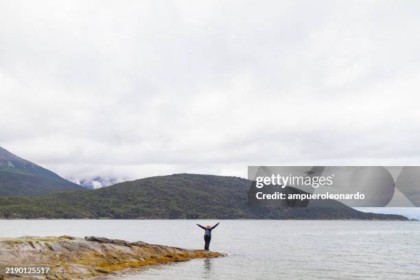 afro mature backpacker stylish female tourist enjoying freedom in ushuaia, tierra del fuego, patagonia, argentina, latin america. - tierra del fuego province chile stock pictures, royalty-free photos & images