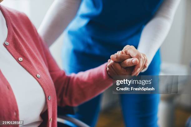 profesional de la salud que ayuda a una mujer mayor a través de una interacción compasiva - atención primaria fotografías e imágenes de stock