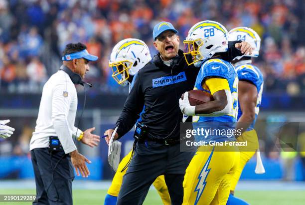 Los Angeles Chargers head coach Jim Harbaugh hugs Los Angeles Chargers running back Hassan Haskins after Haskins scored on a 34 yard touchdown to ice...