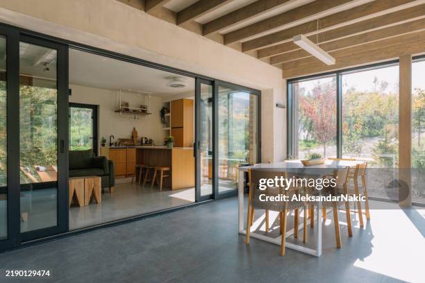 interni moderni della cabina in legno con luce naturale e vista panoramica sulla foresta - porta scorrevole foto e immagini stock