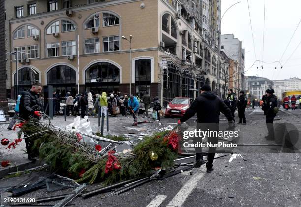 In Kyiv, Ukraine, on December 20 men remove Christmas decorations from the street in the Holosiivskyi district affected by a Russian missile attack....