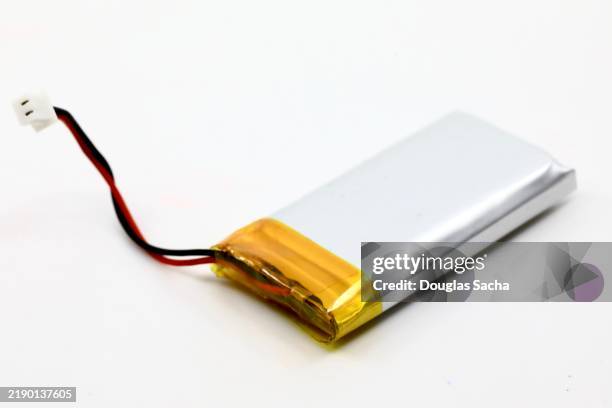 aluminum foil covering on a small lithium battery - wiederaufladbare batterie stock-fotos und bilder