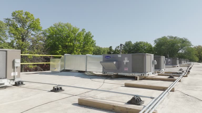 https://media.gettyimages.com/id/2190143614/video/drone-footage-of-industrial-hvac-systems-on-a-flat-commercial-rooftop-surrounded-by-trees-and.jpg?b=1&s=640x640&k=20&c=G45RwlsCOjLIRPUyUSVCExHbcNAmVX122-DCUd6-lRk=