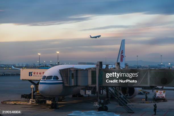 Boeing 787-8 Dreamliner of Air China resupplies at Beijing Capital International Airport in Beijing, China, on December 1 while another plane takes...