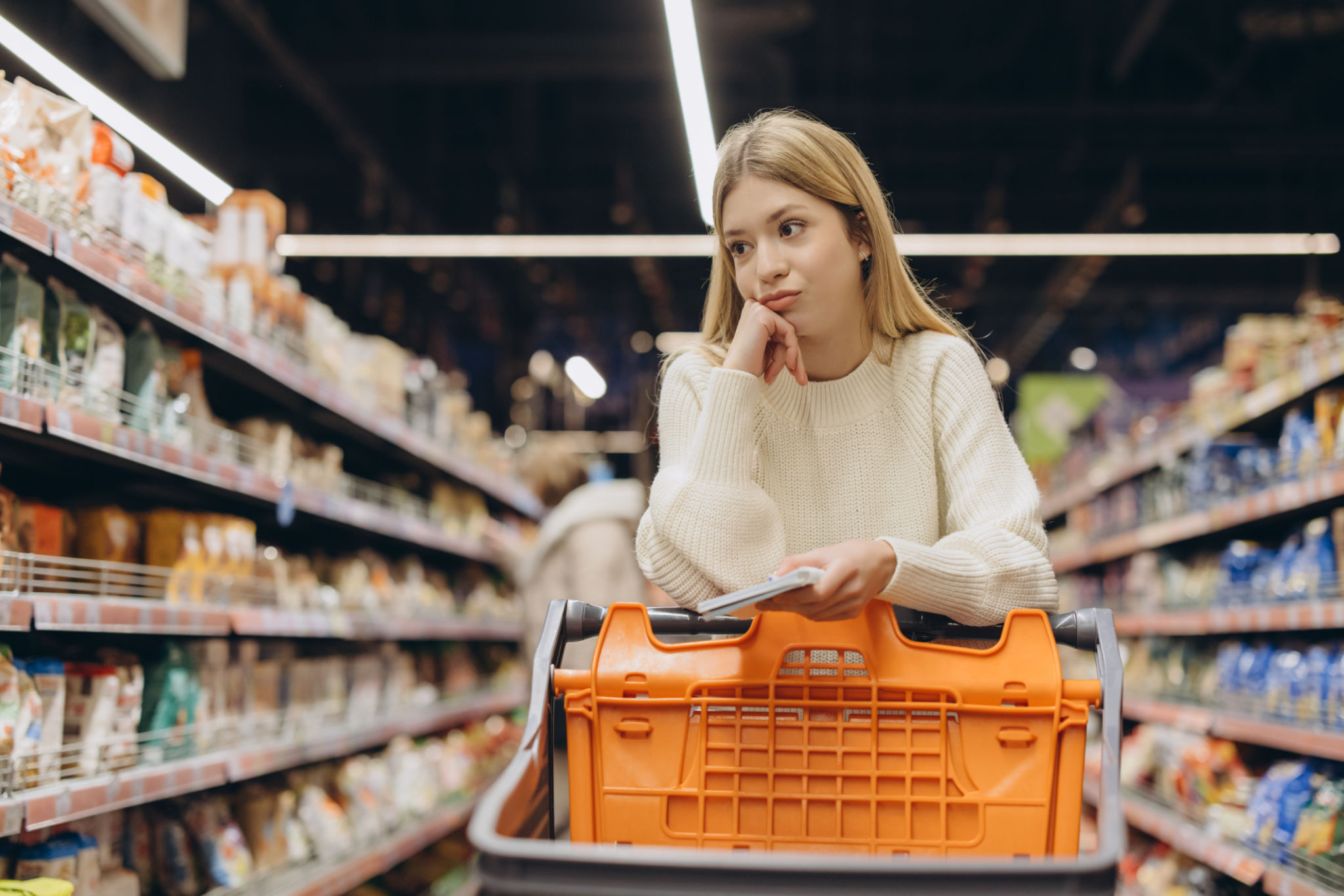 An international student browsing the supermarket for discounted items to save money An international student browsing the supermarket for discounted items to save money