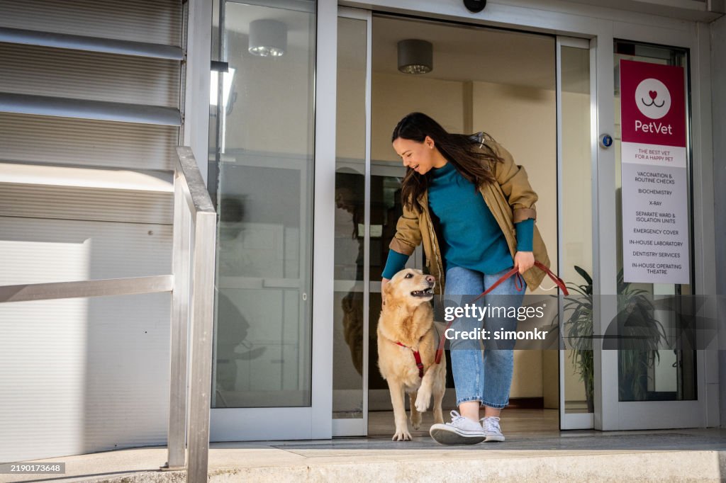 Reife Frau, die Tierklinik mit Hund verlässt