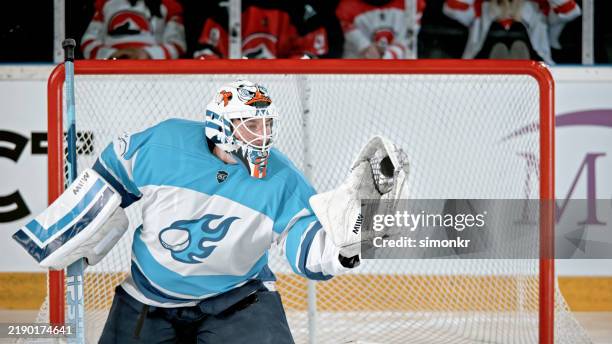 ice hockey goalie blocking a shot - ice hockey player stock pictures, royalty-free photos & images