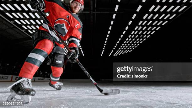 professional ice hockey player close-up: puck control on the ice - ice hockey player stock pictures, royalty-free photos & images