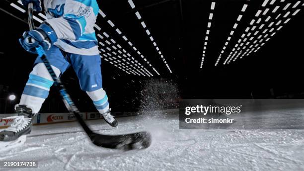 dynamic ice hockey action: hitting the puck, with ice spraying into the air - ice hockey player stock pictures, royalty-free photos & images