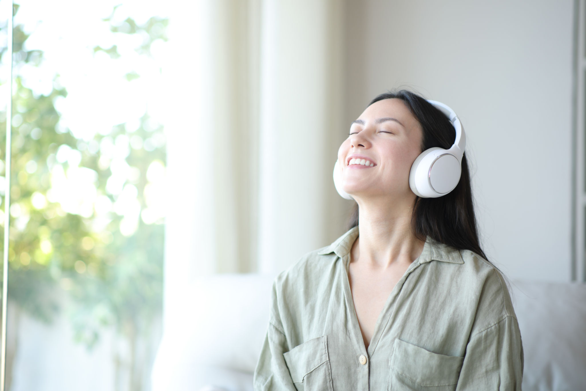 Happy asian woman breathing wearing headphone at home Happy asian woman breathing wearing headphone at home