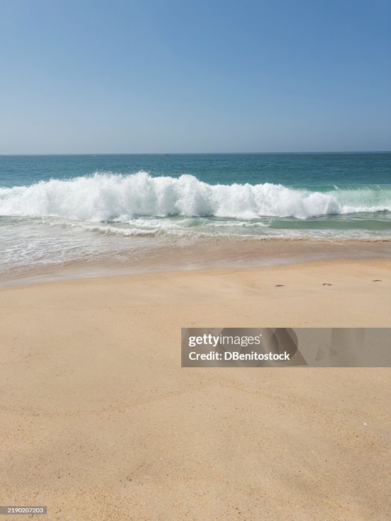Panoramic photo of the beach with sand and waves in Nazaré, Portugal. Vacation, surfing, giant waves, tourist destination, summer, surfing and surfer.