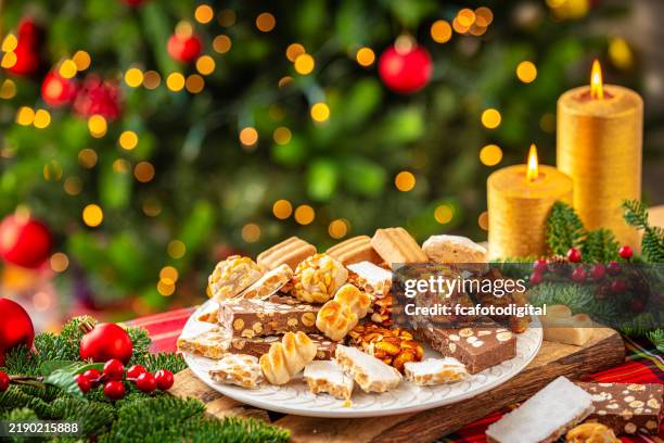 teller gefüllt mit leckerem nougat und marzipan auf dem weihnachtstisch. traditionelle spanische süßspeisen zu weihnachten - knusprig stock-fotos und bilder