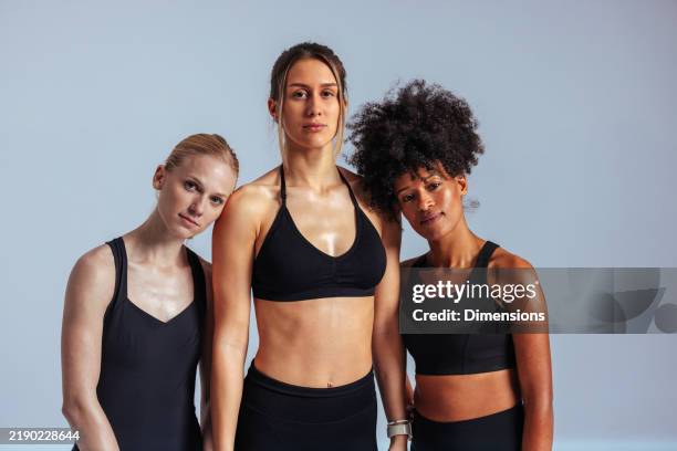 tres mujeres en forma posando juntas después de hacer ejercicio - diferentes edades fotografías e imágenes de stock