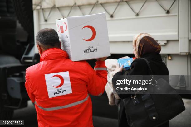 Members of the Turkish Red Crescent distribute aid parcels after the opening ceremony of the new delegation office in the Syrian capital Damascus on...