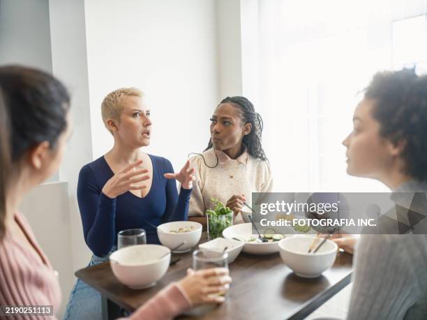 young multiracial group of female friends enjoying vegetable curry dish at the kitchen - alleen jonge vrouwen stockfoto's en -beelden
