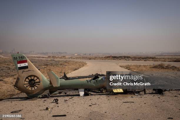Syrian Air Force helicopter is seen destroyed after Israeli strikes against military targets across Syria at Mezzah Military Airport on December 16,...