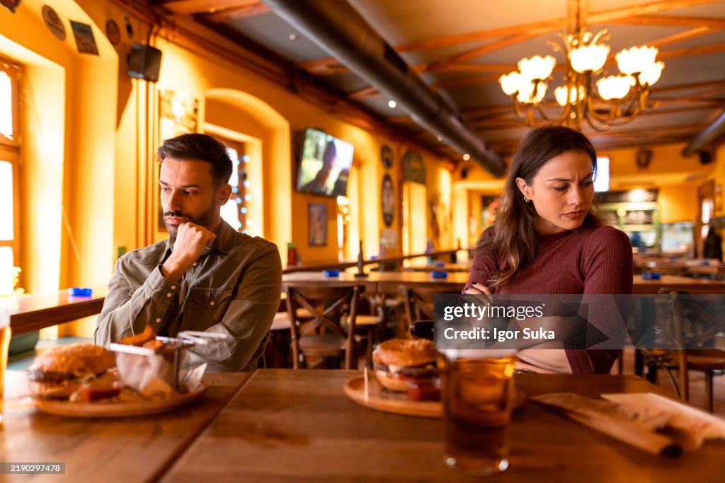 Young couple arguing while having dinner at restaurant