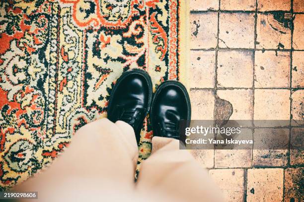 an unrecognizable person standing on a patterned rug next to a tiled floor surface - camera point of view stock pictures, royalty-free photos & images