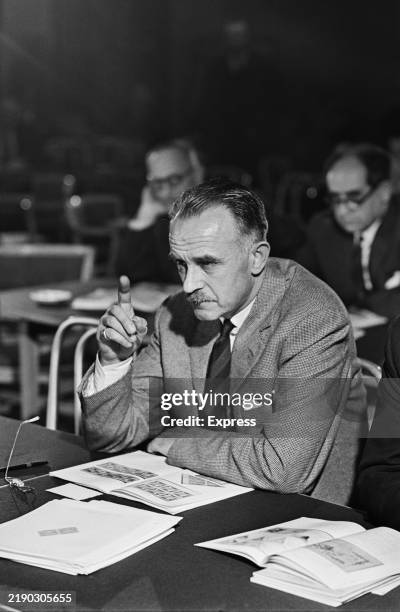 Philatelist Miroslaw Bojanowicz raises a finger while seated at a stamp auction, November 28th 1962.