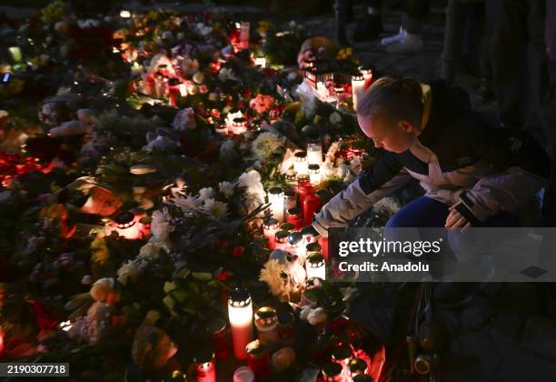 People light candles and leave flowers in front of St. Johannis Church, across from the Christmas market where the car-ramming attack occurred, in...