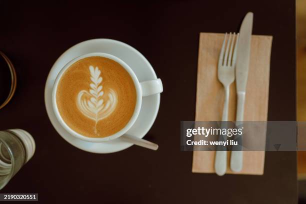 table top view of latte in a white ceramic cup on a wooden table - hafermilch stock-fotos und bilder
