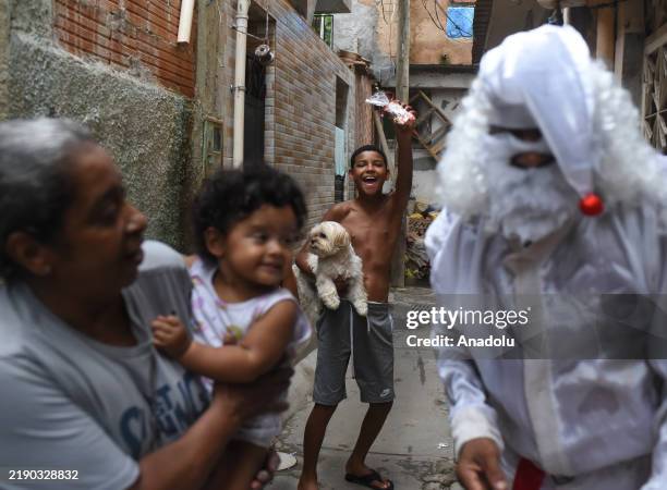 Man in Santa Claus costume visits the favela of Mare to give candy and presents to children in Rio de Janerio, Brazil on December 21, 2024.