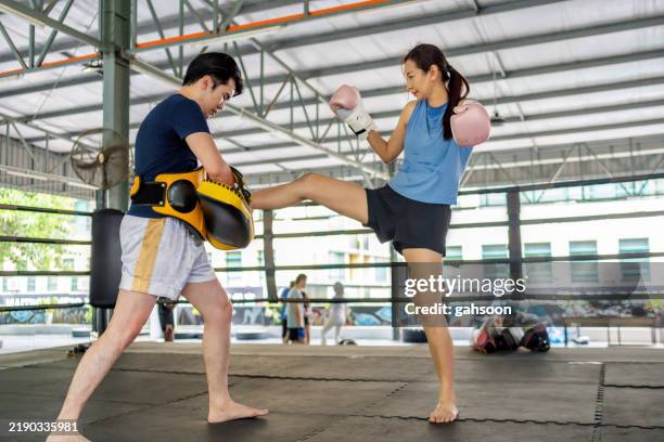 luchadora practicando muay thai con entrenador - muay thai fotografías e imágenes de stock