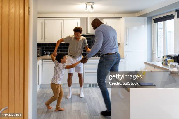 padre e figli che ballano in cucina - home sweet home espressione inglese foto e immagini stock