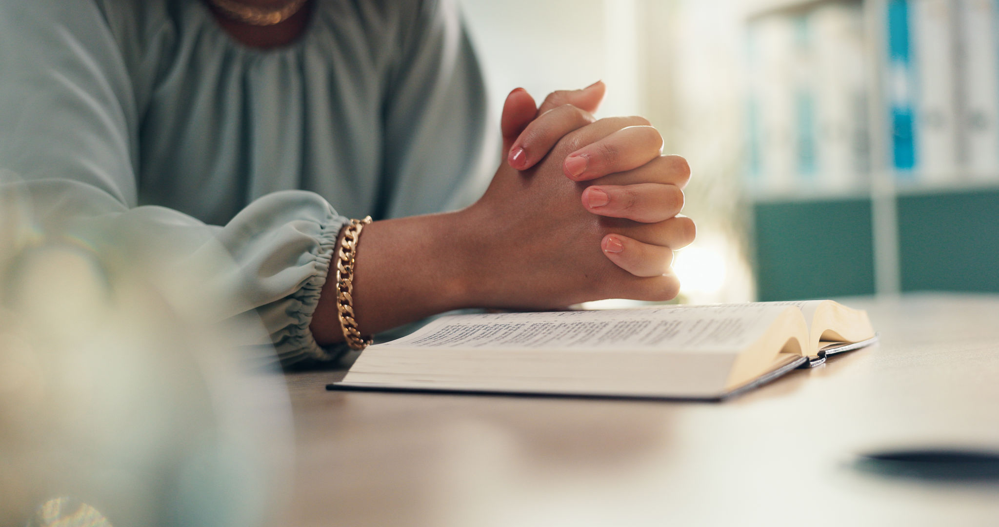 Hands, prayer and bible for religion in home with worship, peace and reading for spiritual guide. Person, Christian book and faith with reflection with scripture for connection to God at apartment Hands, prayer and bible for religion in home with worship, peace and reading for spiritual guide. Person, Christian book and faith with reflection with scripture for connection to God at apartment