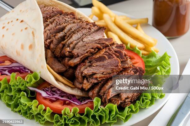 a plate of doner kebab with a generous serving of shredded beef meat - gyros stock-fotos und bilder