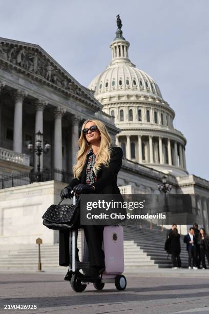 Celebrity hotel heiress Paris Hilton is photographed by a member of her team as she rides an Airwheel electric scooter luggage outside the U.S....
