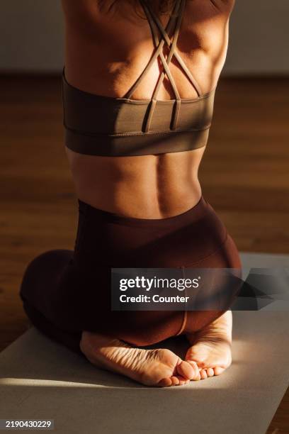 back of woman practicing yoga - tapis de sol photos et images de collection