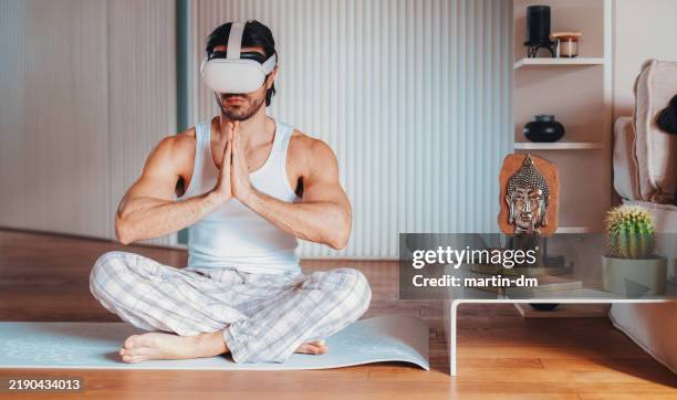 man at home practicing yoga with vr glasses - simulator stock pictures, royalty-free photos & images