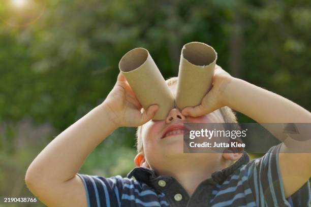 young boy looking through empty toilet paper rolls - binoculars stock pictures, royalty-free photos & images